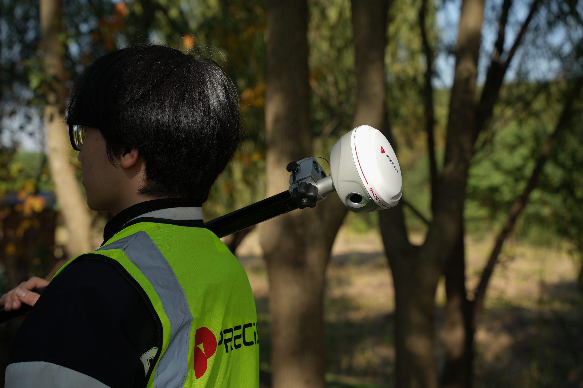 PRECISE X7 mounted on a survey pole in a wooded field site