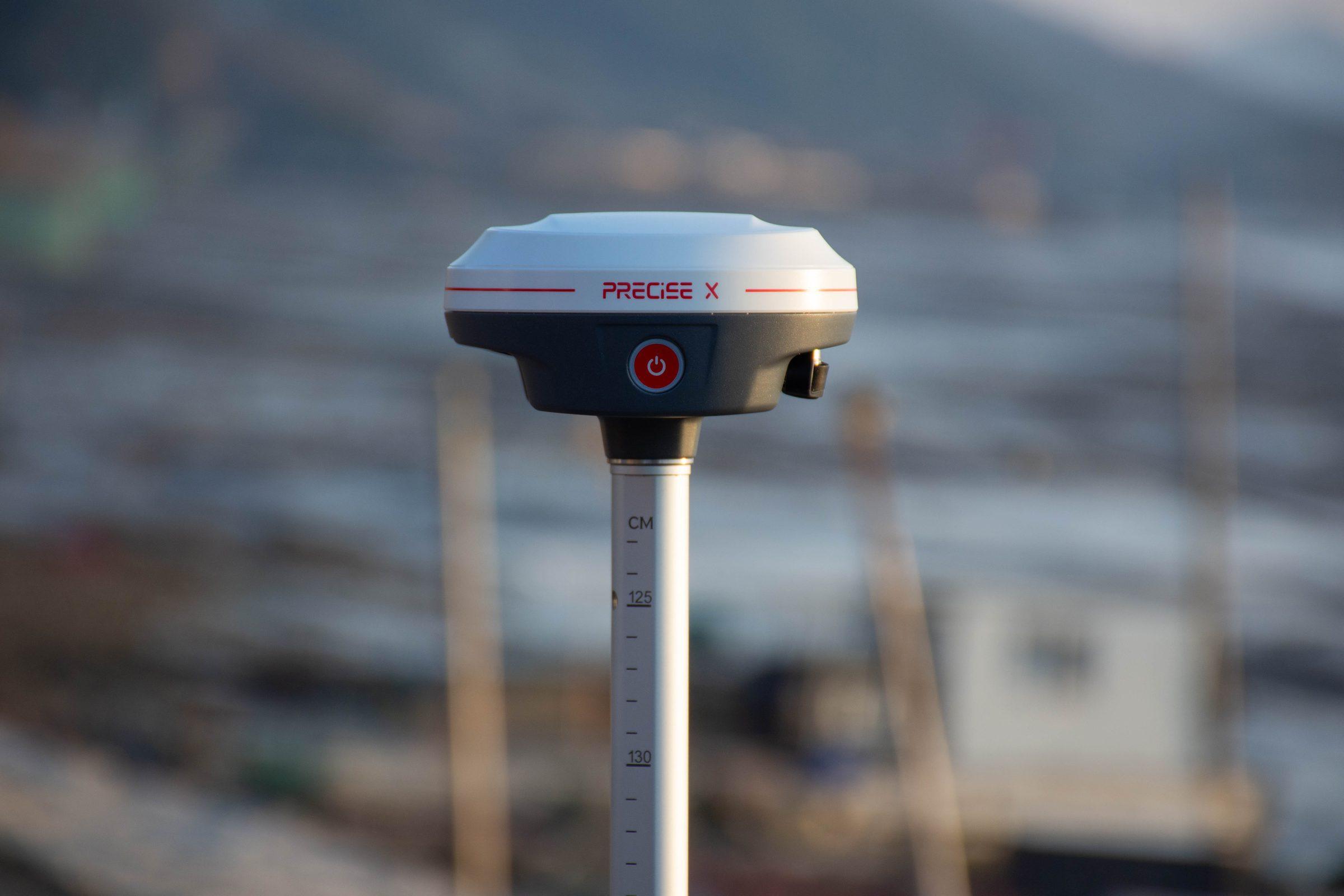 PRECISE X mounted on a survey pole outdoors at golden hour
